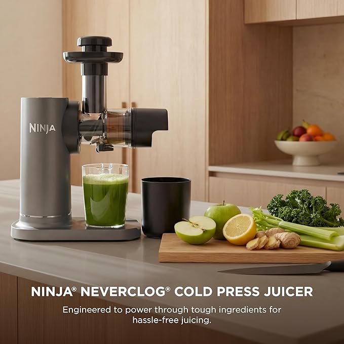 Cold press juicer with juice and pulp containers, stainless body on a kitchen counter