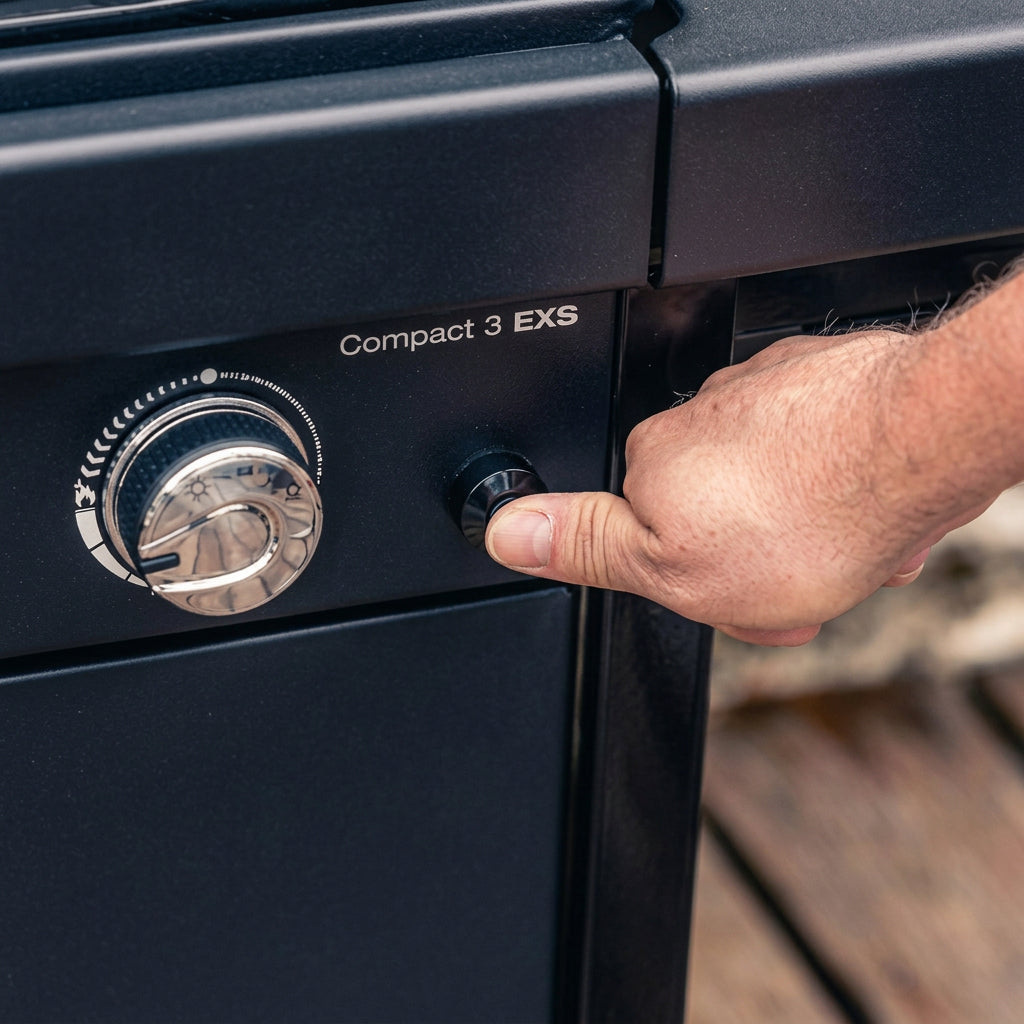 BBQ grill control knob being turned on black control panel