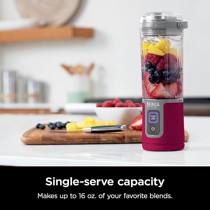 Ninja smoothie maker with clear jar and magenta base filled with fruit