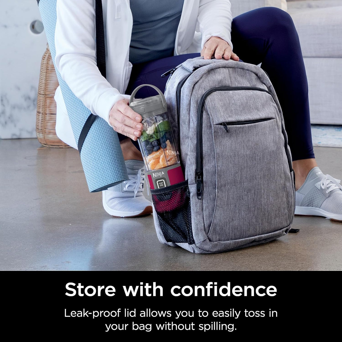 Portable smoothie blender with clear jar and magenta base stored in a gray backpack
