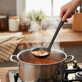Black soup ladle scooping soup from a pot, with visible steam