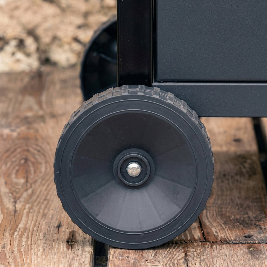BBQ grill caster wheel with metal axle, close-up on dark rubber tire