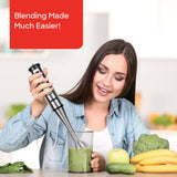 Handheld stick blender with blending shaft and control buttons in use
